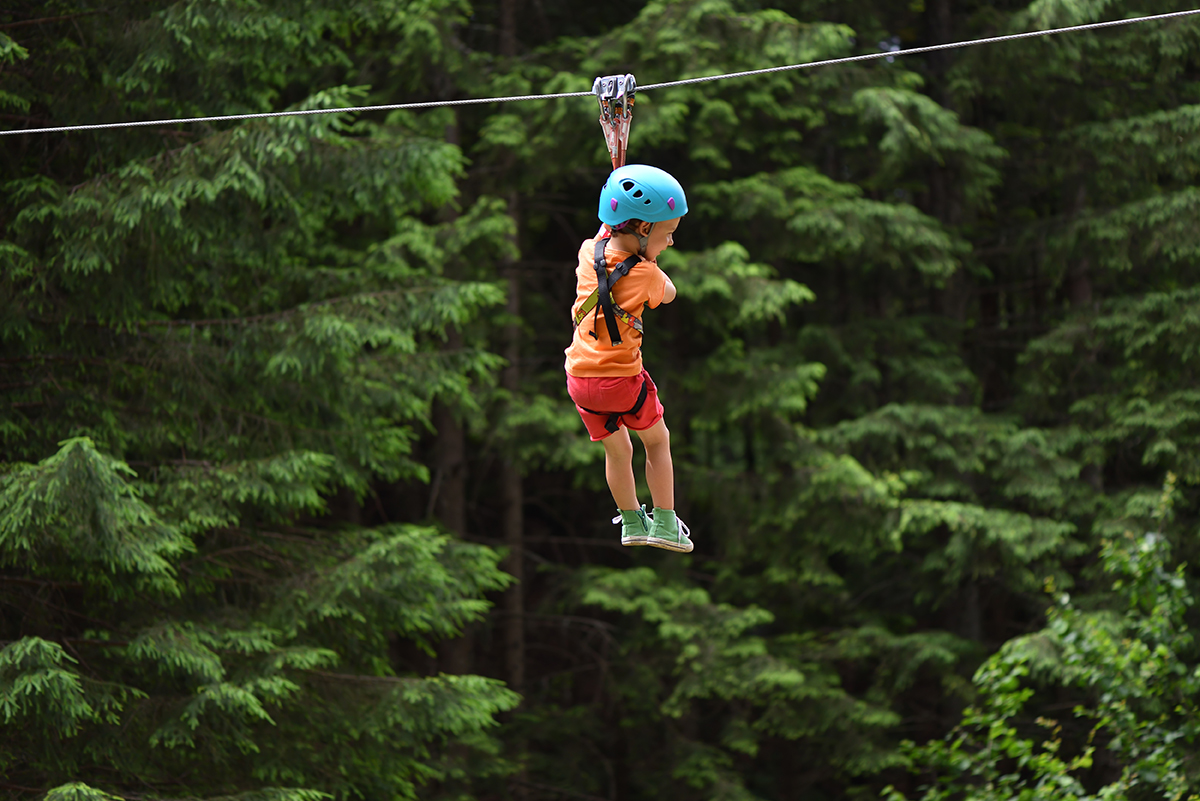 Little girl on a zip line adventure in the trees