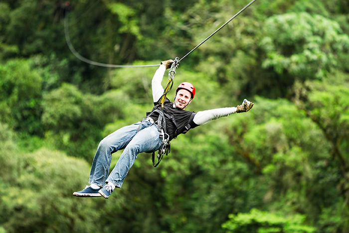 Man enjoying his zipline adventure through the trees