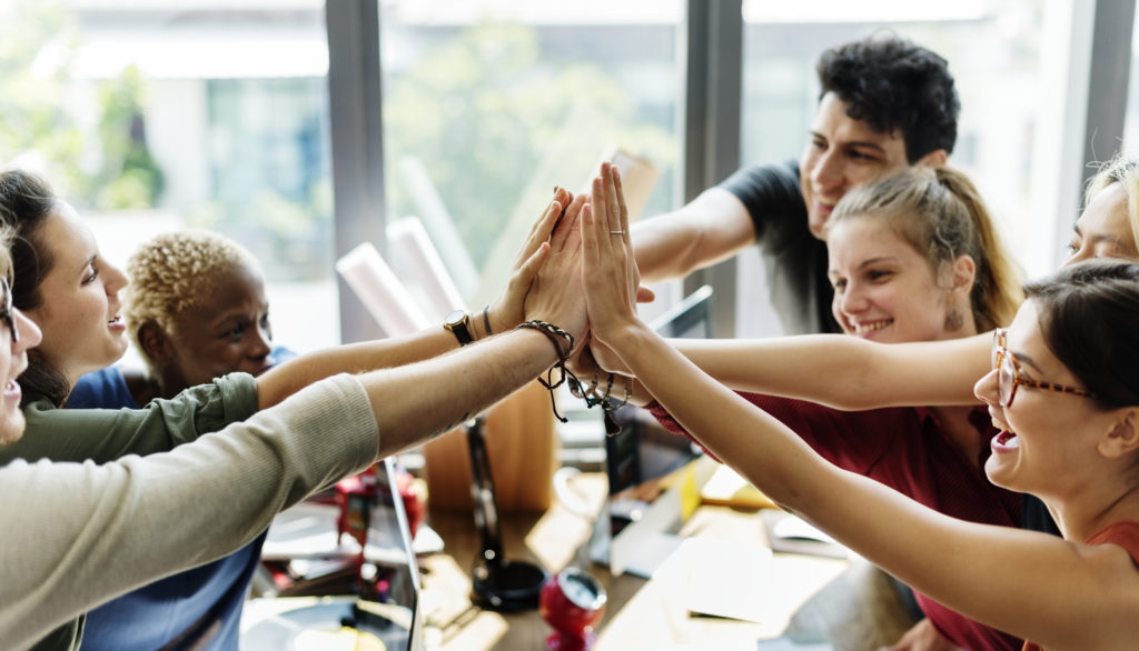 Office workers high-five after corporate team building