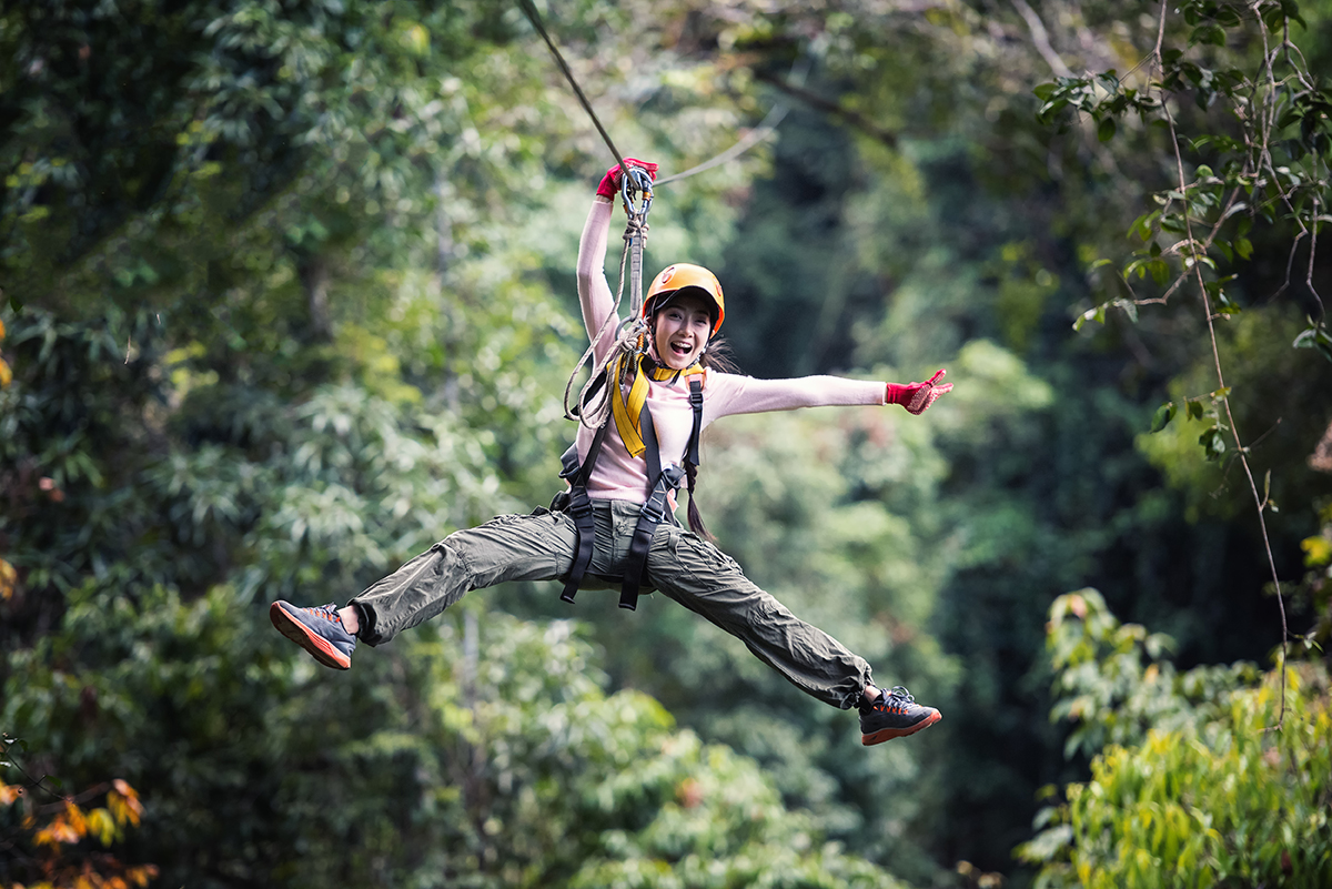 Young woman having fun on a zipline adventure tour